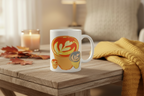 The mug is placed on a wooden table, surrounded by a few fall leaves, a mustard-yelllow scarf and a candle. A cozy feeling, a throw pillow and warm ligting in the background
