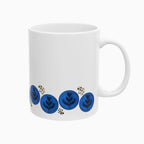 Latte art tulip in a zigzag pattern (up/down) surrounding the bottom of the mug. This is a "negative" view of the original photo, so the tulip is black now and the brown foam is blue. A group of dark brown dots in different sizes, maybe reminding of coffee beans or grounded coffee, are placed in a few places across the design, near the tulips